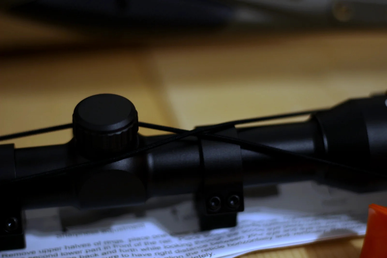 The 4x32 scope sitting in its two mounting rings on the bench