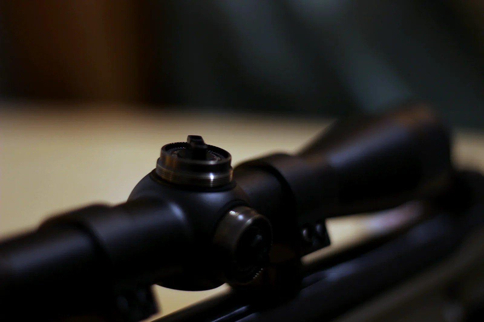 The scope with its turret caps removed showing the adjustment screws