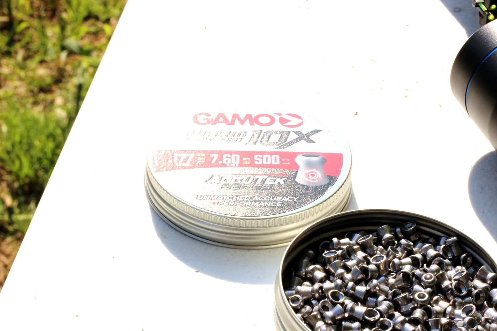 Domed lead pellets spilled from an open tin