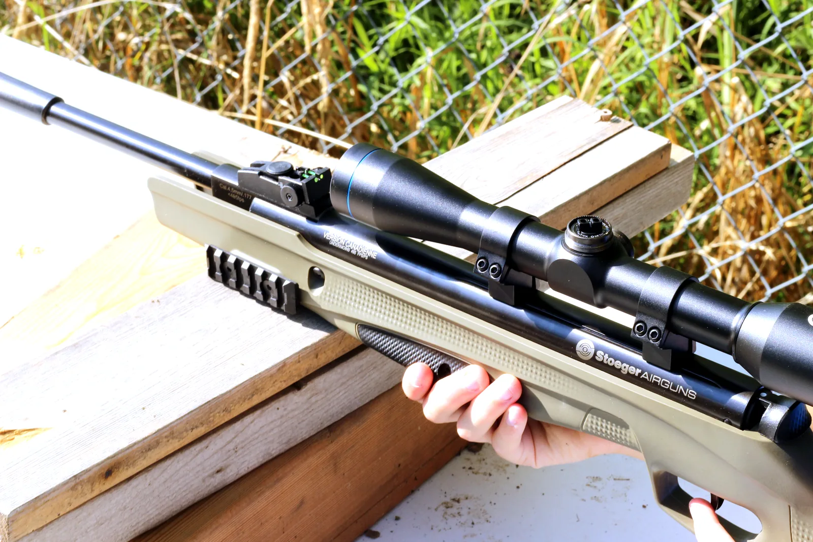 A young shooter seating a pellet into the open breech of the broken-open rifle