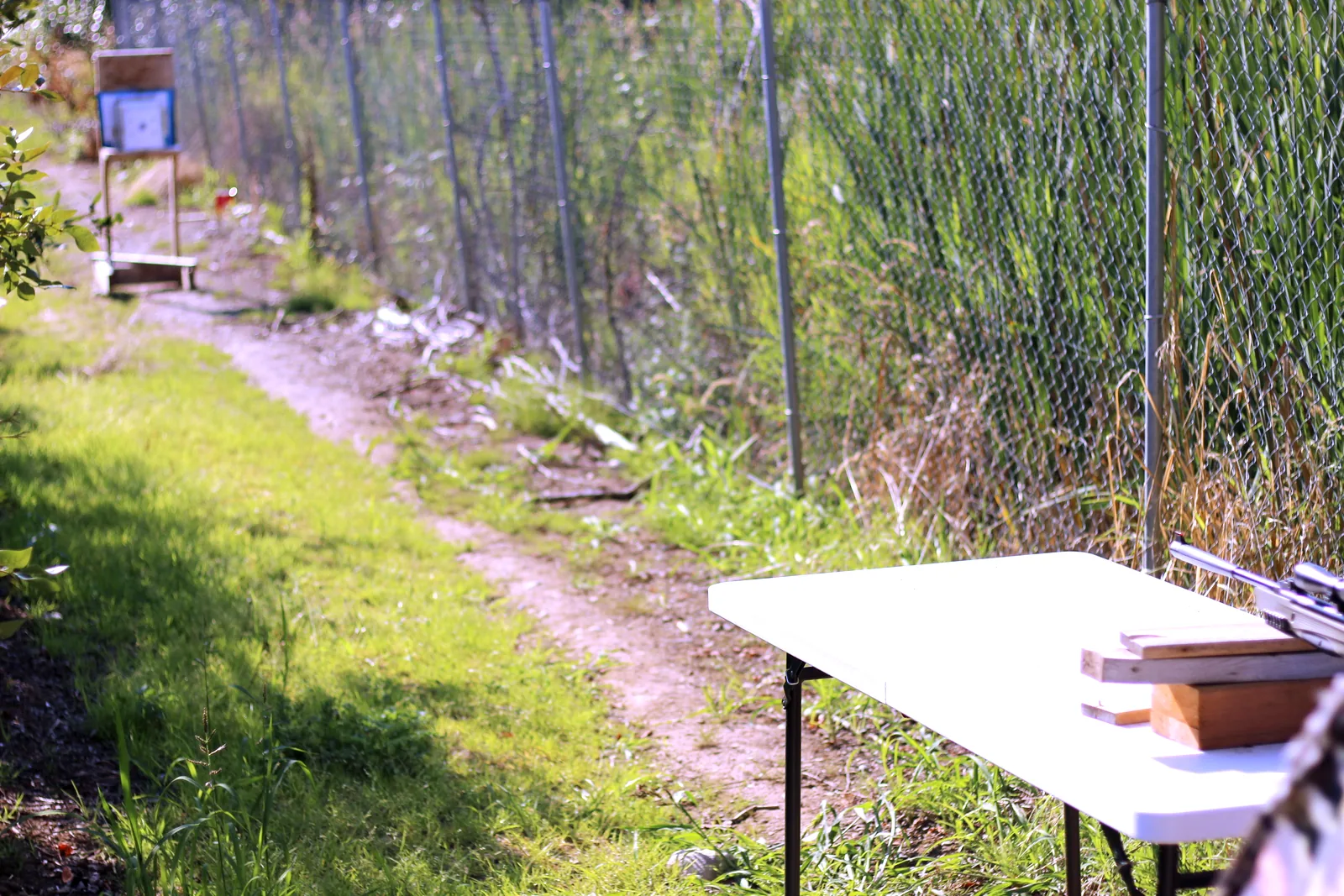 The bench in the foreground with the rifle on it and the target frame in the distance