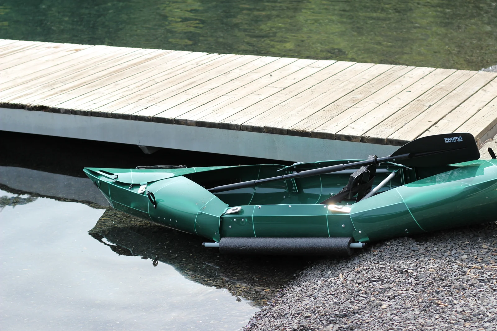 Tucktec Pro kayak staged at the edge of a wooden dock partly in shallow water ready for launch