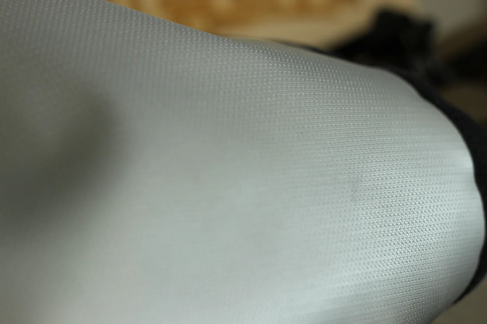 Macro of the pale grey woven flame-retardant stove jack material showing its tight basket weave