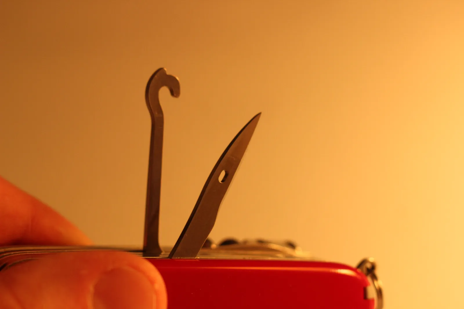 Side view of the closed Victorinox SwissChamp on a tan surface showing the layered tool stack