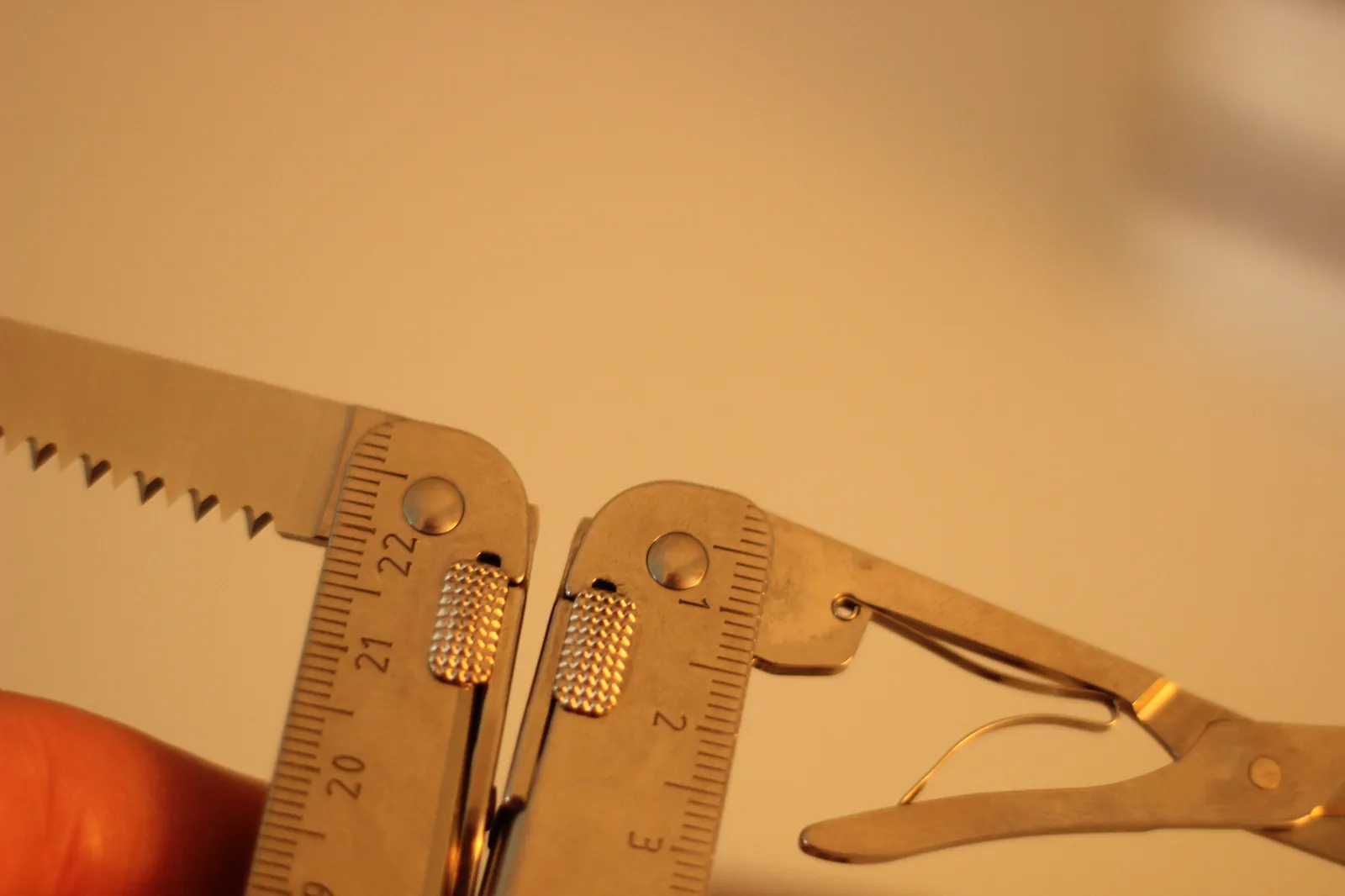 The Swiss Tool MX Clip from the opposite side showing the wood saw at left and the scissors at right with ruler markings reading toward 22 cm