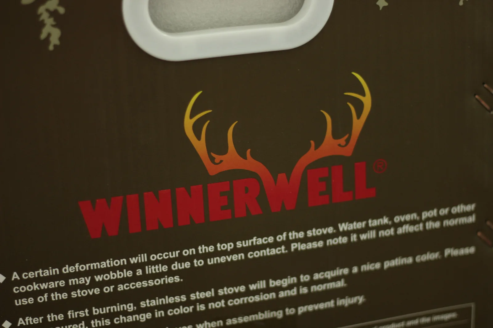 The Winnerwell antler logo printed in a red-to-gold gradient on the dark carton, with printed guidance text below it