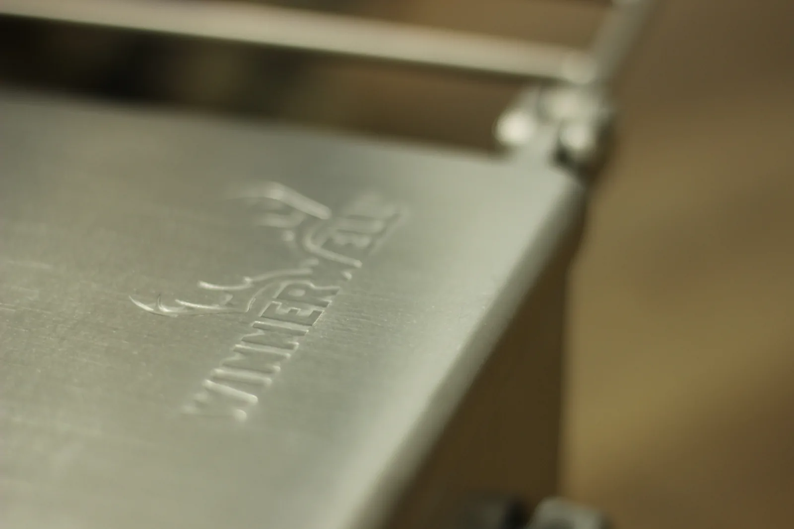 The same embossed logo photographed in raking light so the relief of the stamping is visible