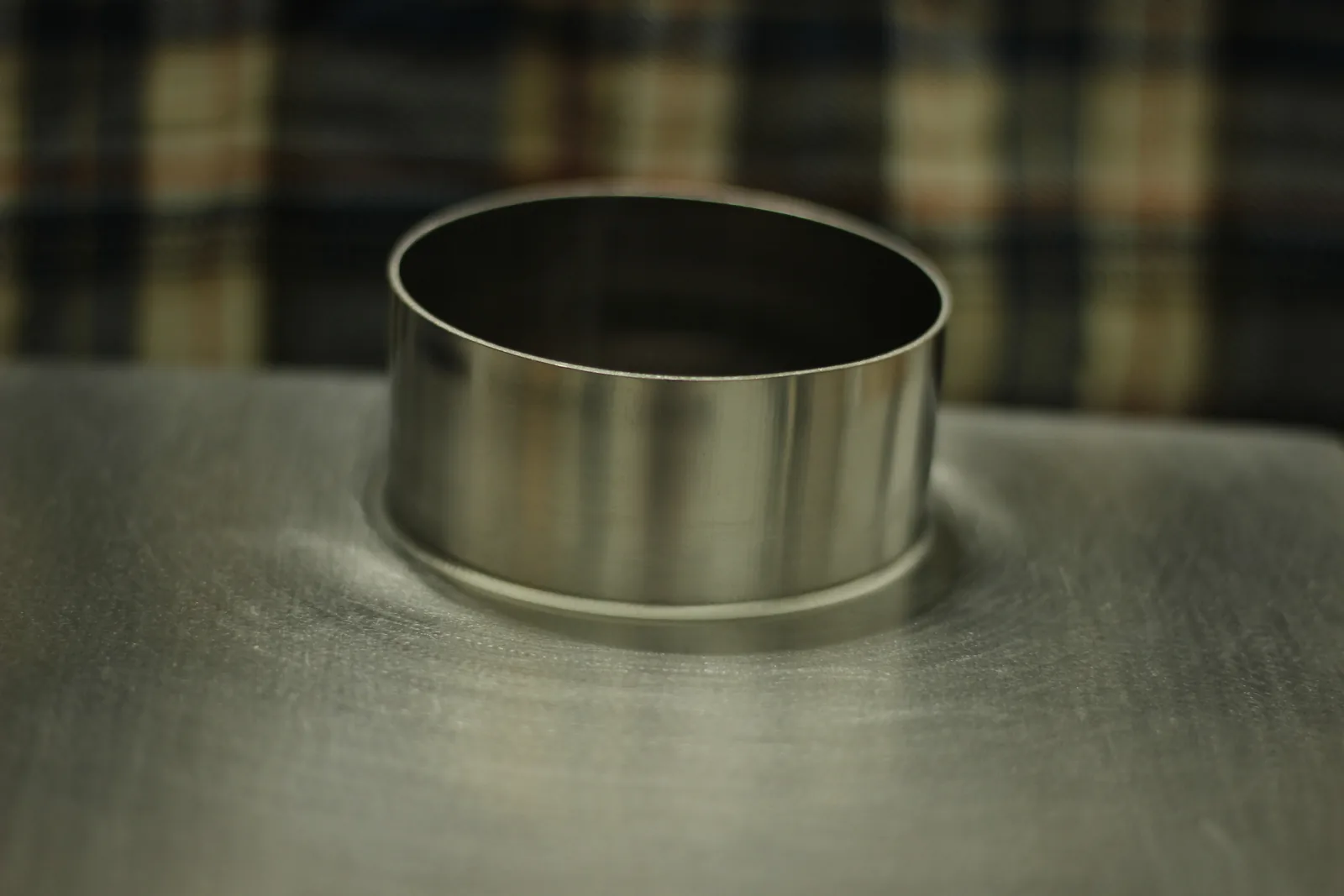 Close-up of the flue collar rising from the top plate with the metal drawn smoothly up into the cylinder