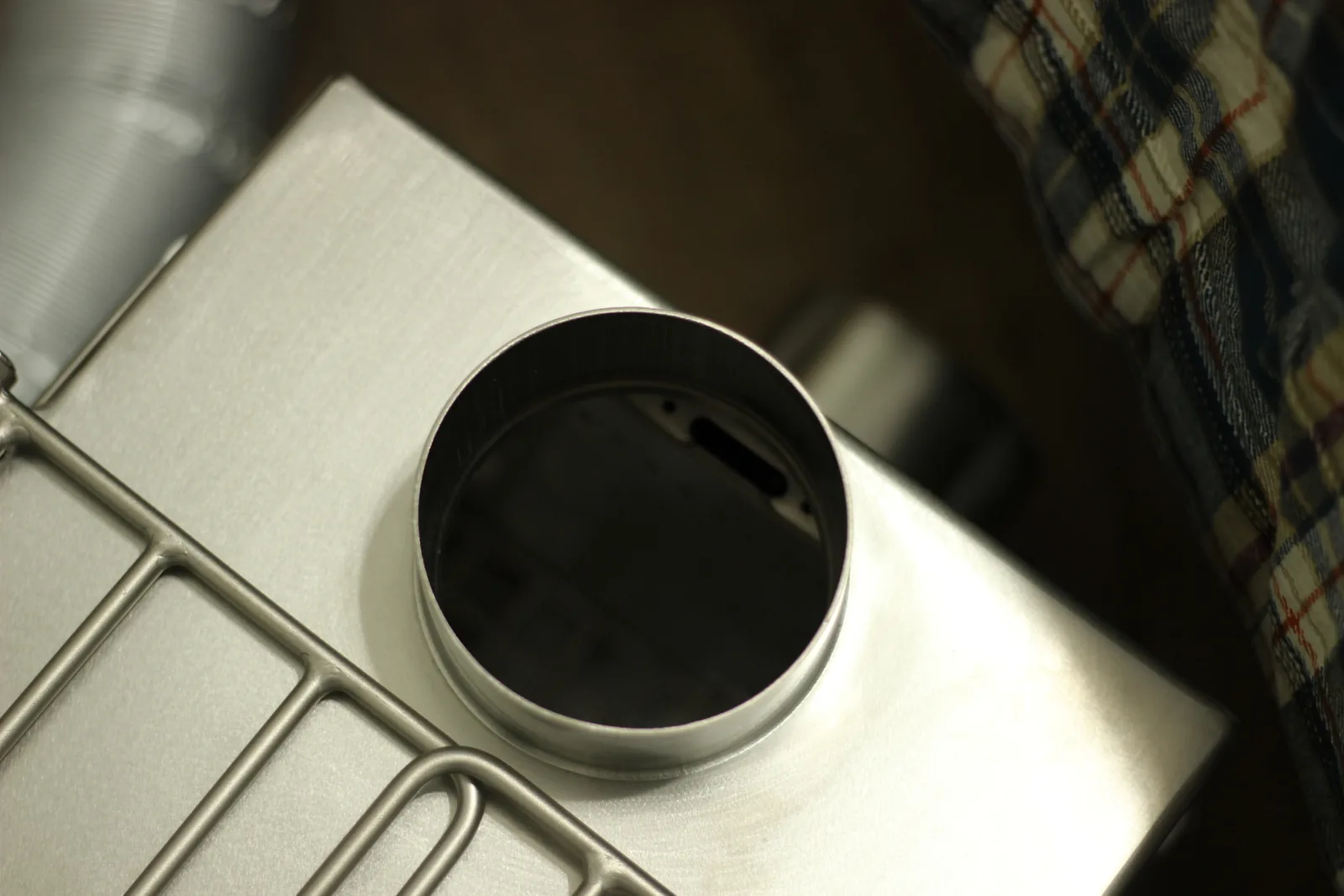 Looking down into the flue collar on the stove top with the damper plate visible inside