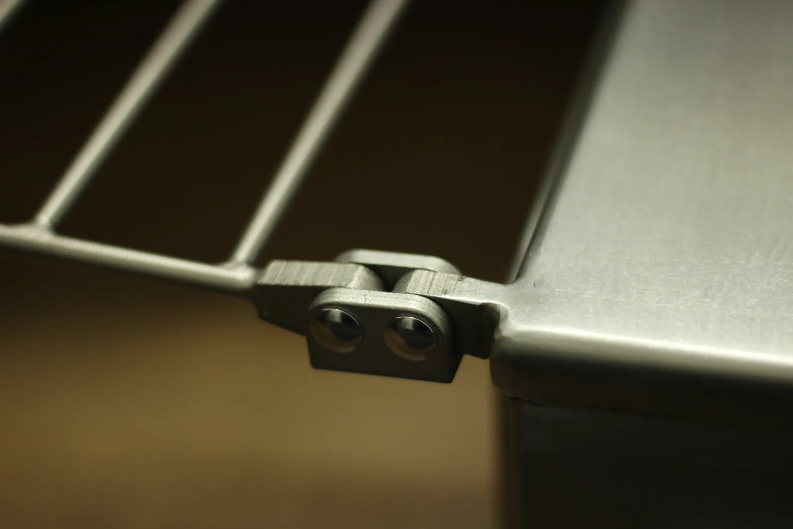 Macro of the bracket where it meets the stove wall, showing the clean fit of the joint