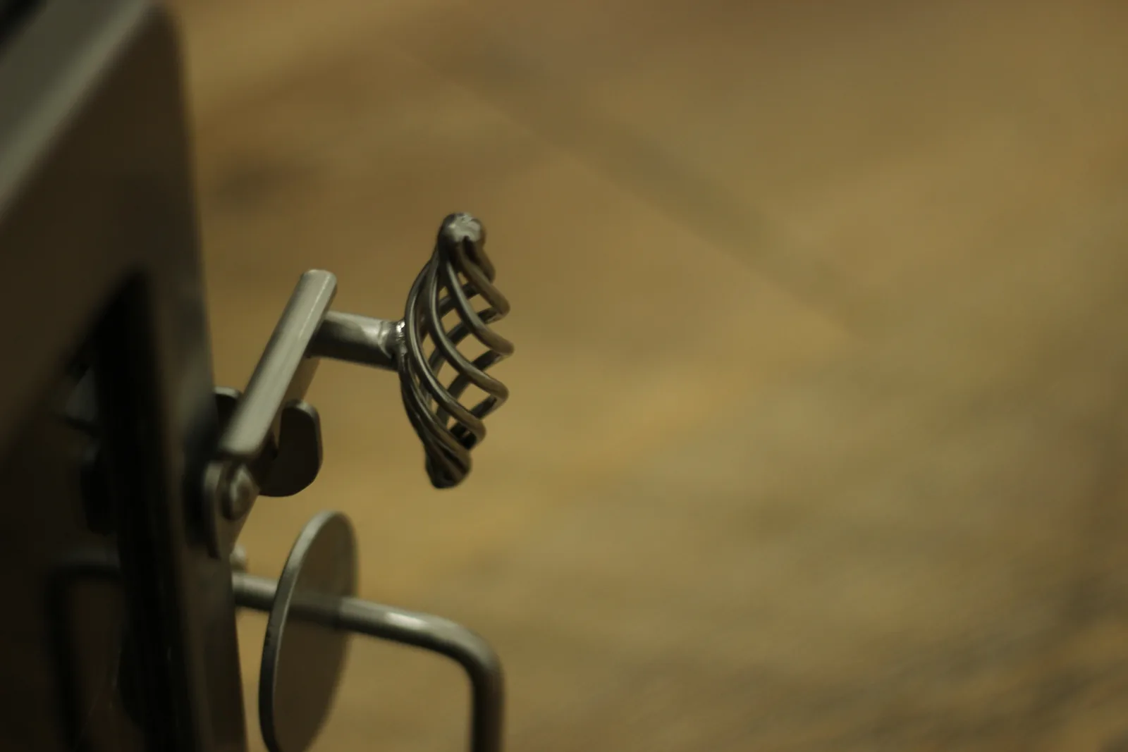 The spring handle beside the flat cam latch that clamps the door shut