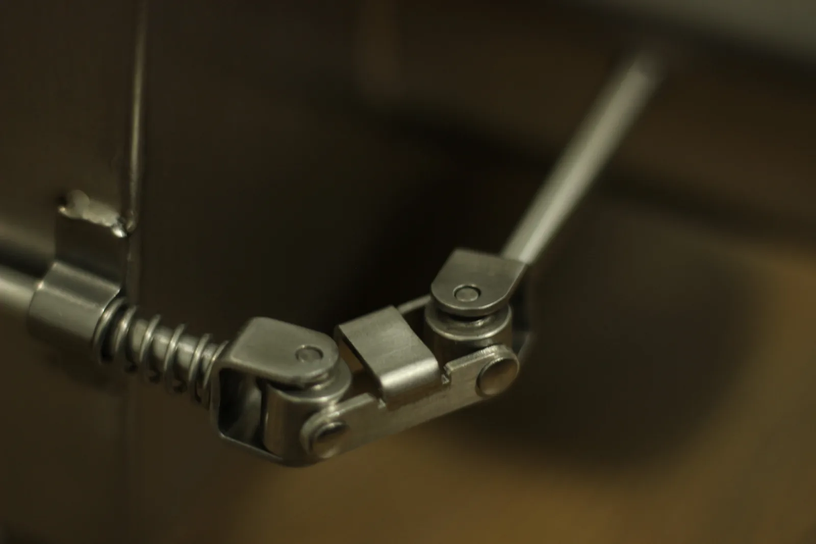 Close-up of the door handle linkage where the spring coil meets the latch shaft