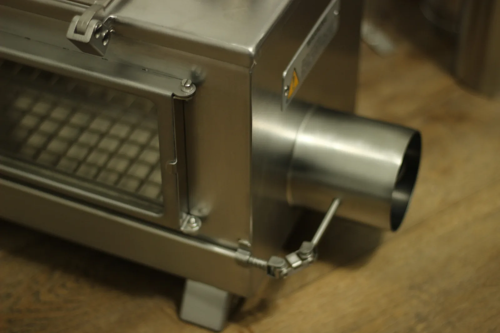 The circular external air intake port on the side of the stove body with its collar for the flexible duct
