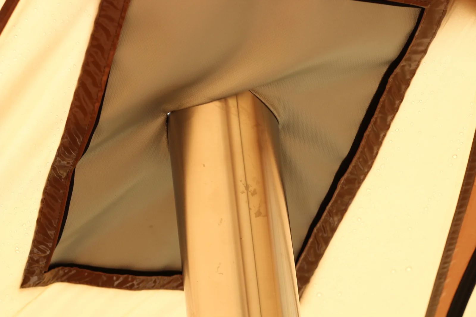 Close-up of the tent's stove jack fabric drawn snug around the stainless chimney pipe