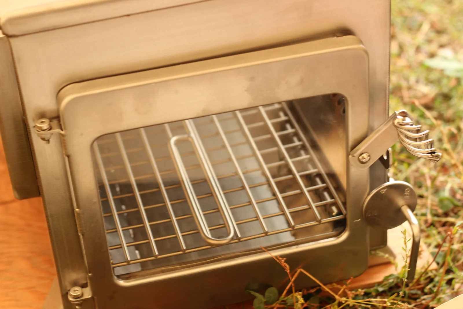 The stove door standing open on the empty grate, ready to be loaded