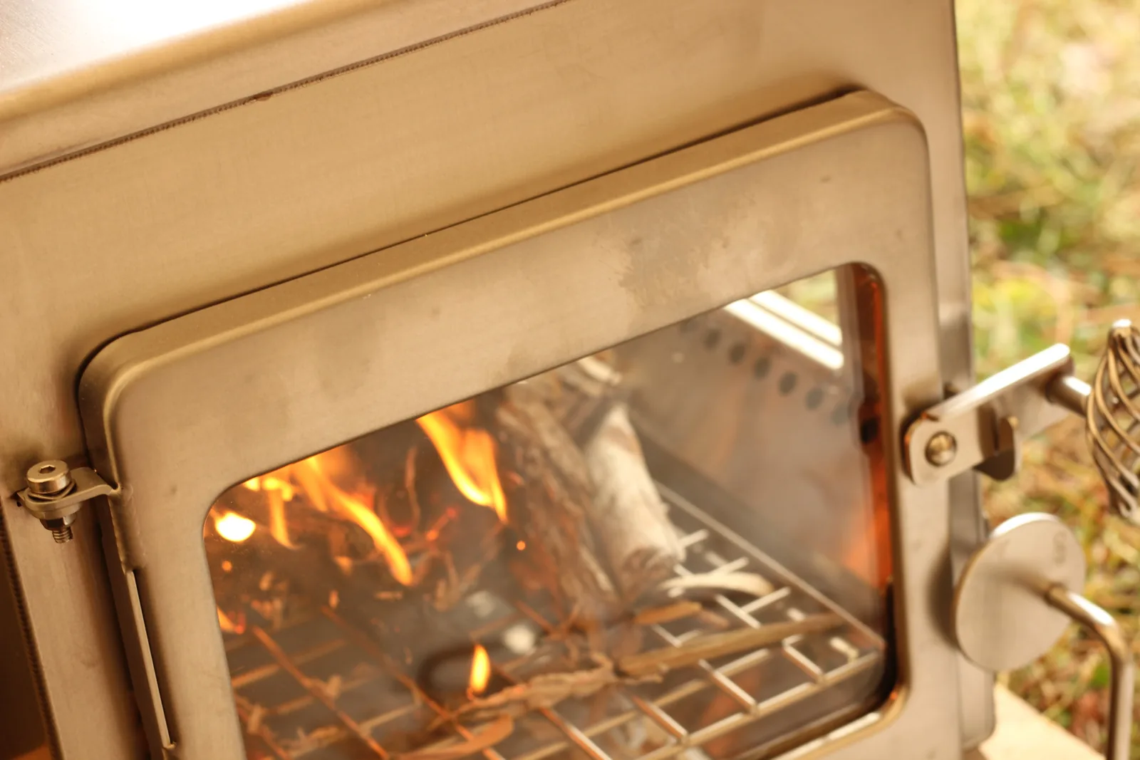 The front door window showing an established fire on the grate with the latch and spring handle in frame