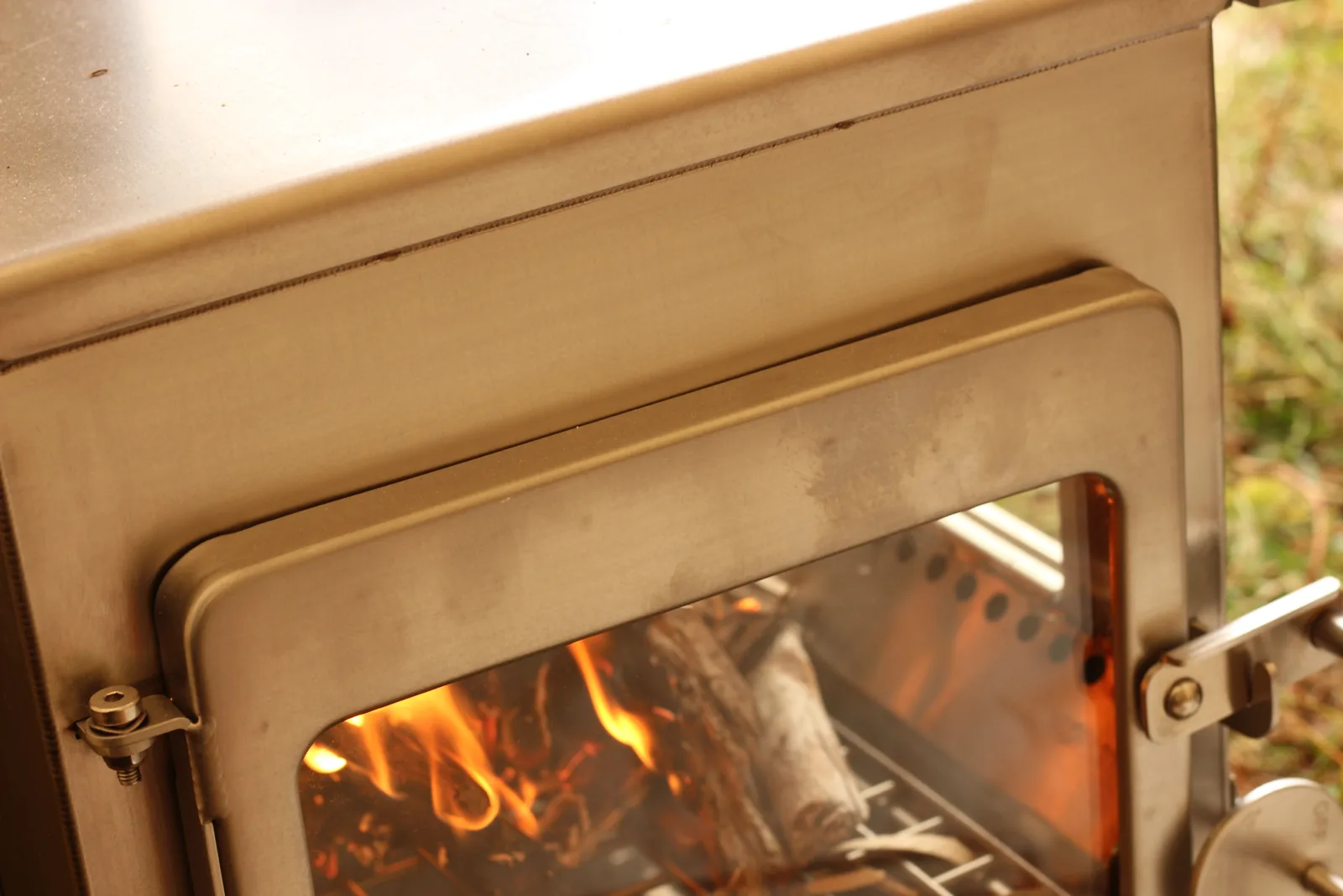 The stove from an angle showing fire visible simultaneously through both the front and the side glass