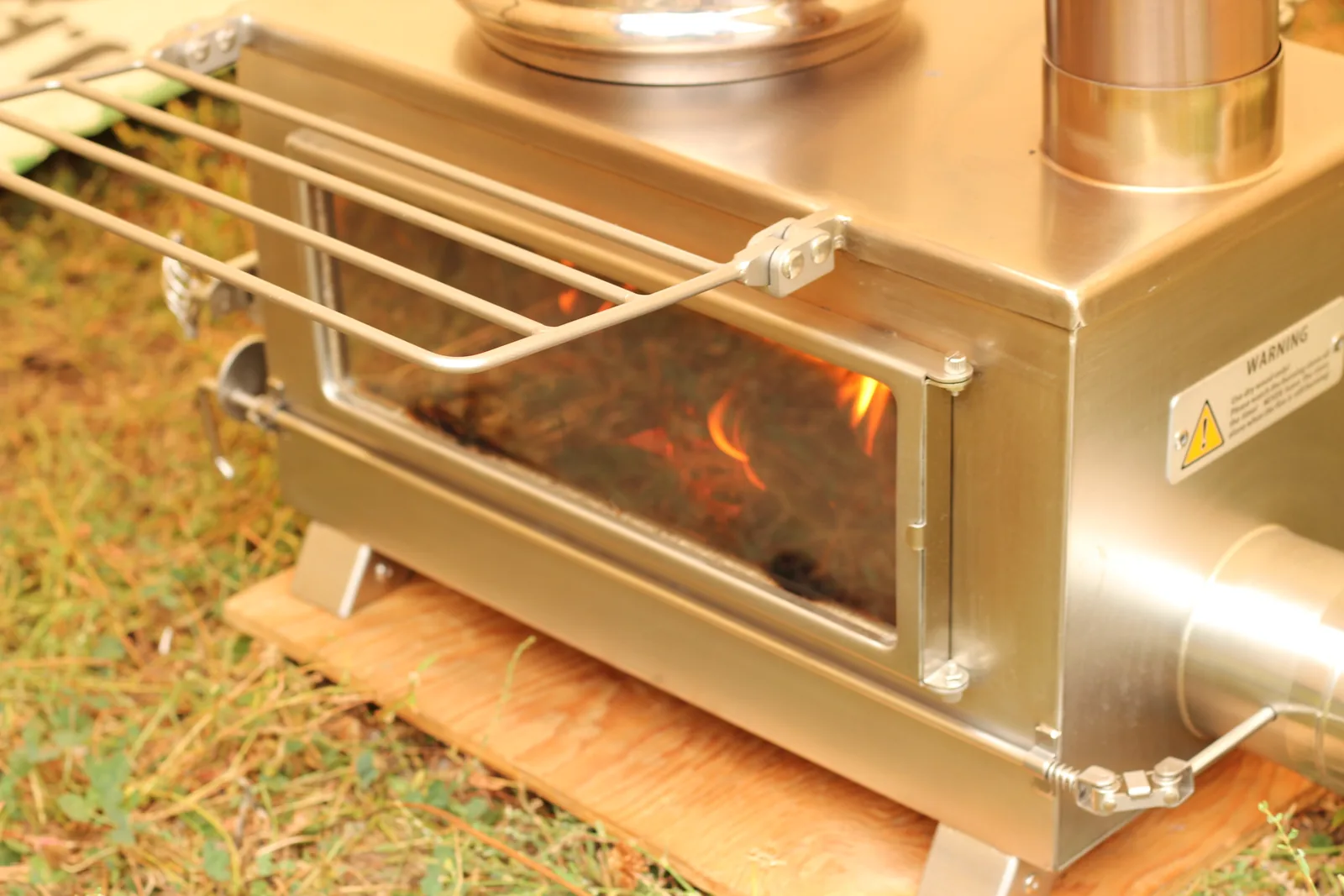 The stove and kettle at the end of the day, fire burning low behind the glass
